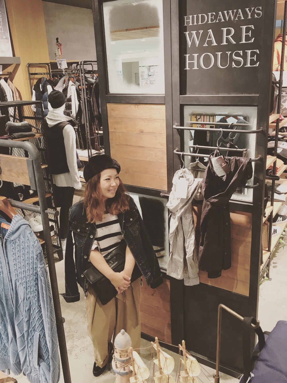 ブルー系のデニムジャケット、ブラック系のクラッチバッグ、ベージュ系のパンツを着用したレディースの秋コーディネートの1枚目の写真