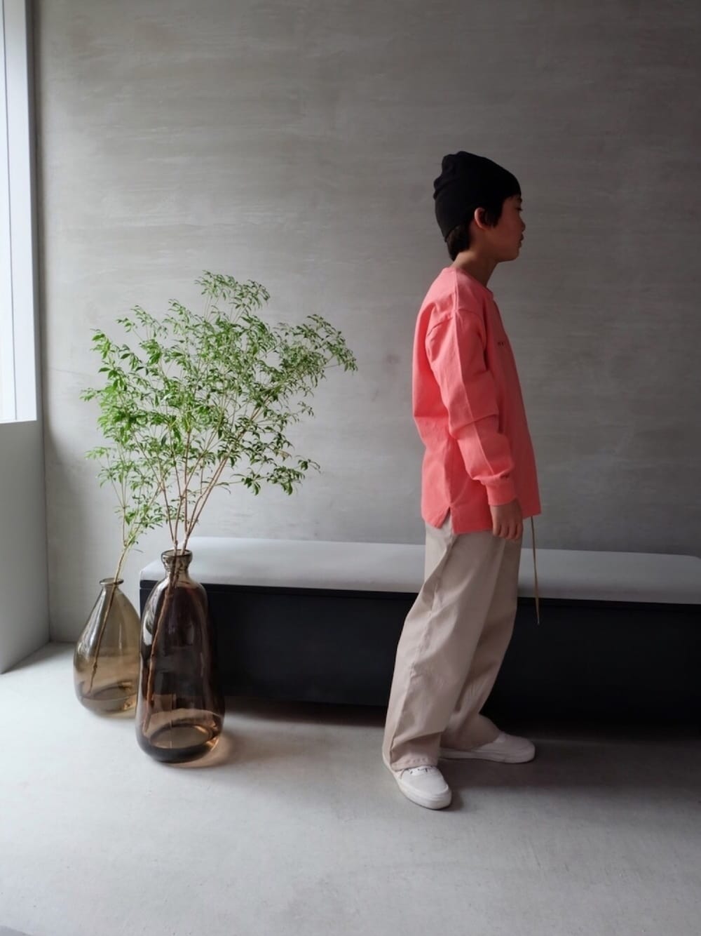 オレンジ系のTシャツ/カットソー、ホワイト系のスニーカー、ベージュ系のチノパンツを着用したキッズの春コーディネートの1枚目の写真