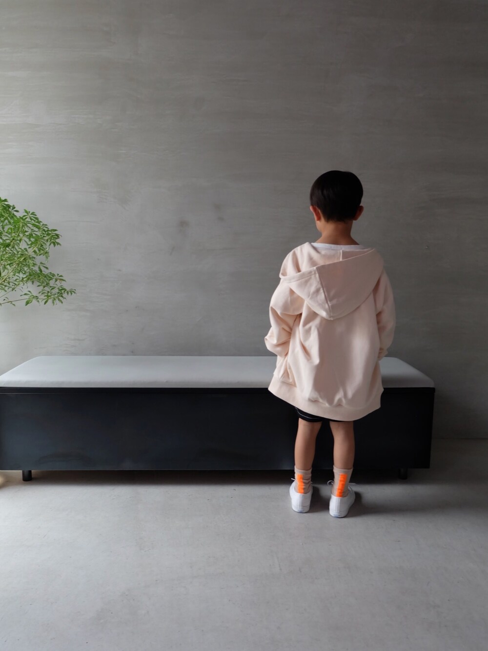 ベージュ系のパーカー、ホワイト系のスニーカーを着用したキッズの春コーディネートの1枚目の写真