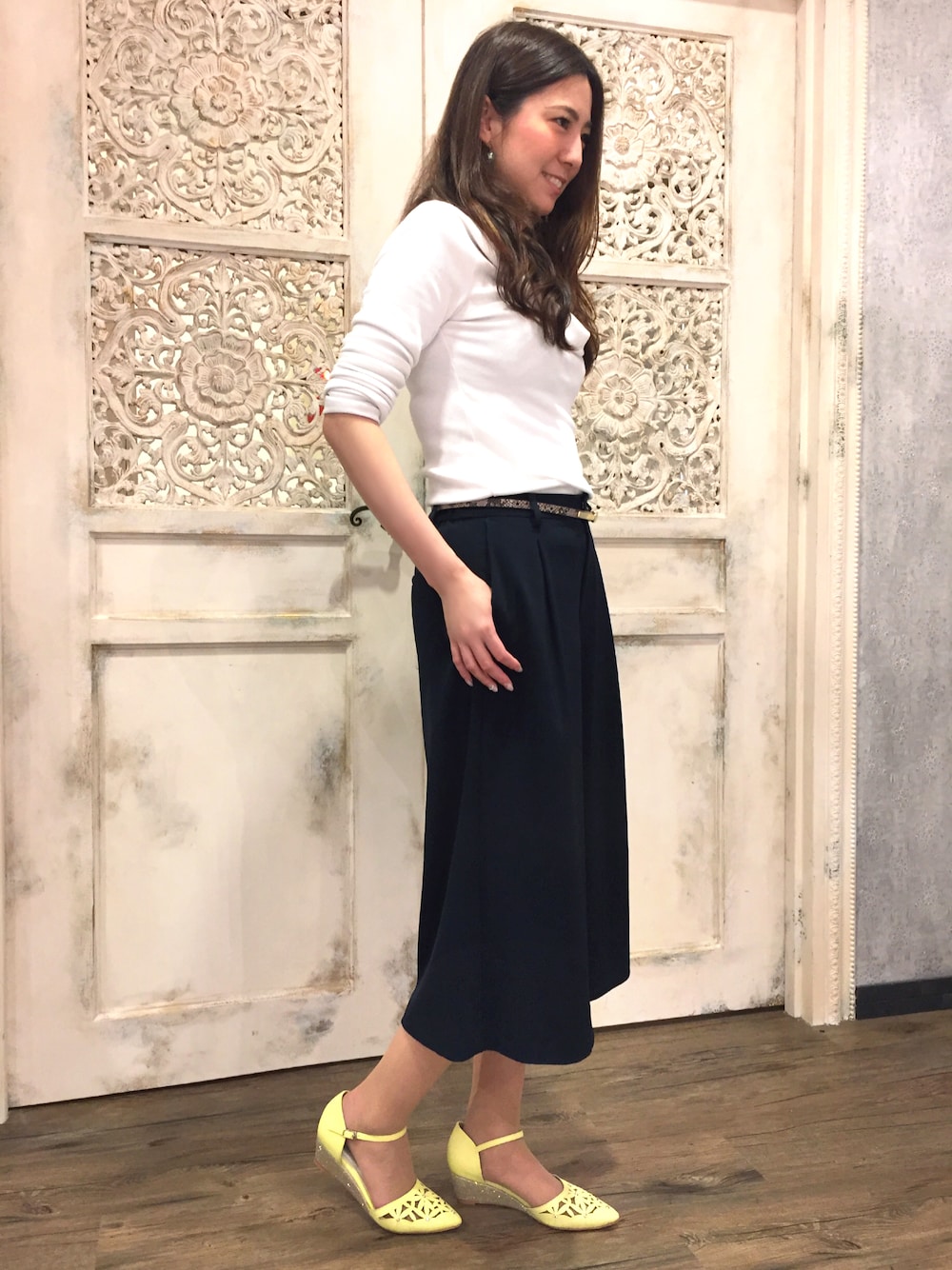 イエロー系のサンダルを着用したレディースの春コーディネートの1枚目の写真