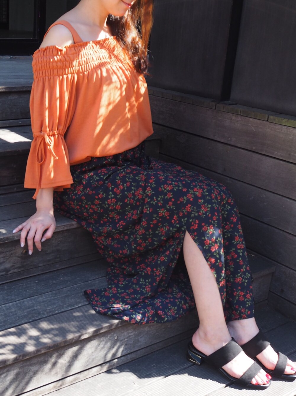 ブラック系のサンダルを着用したレディースの夏コーディネートの1枚目の写真