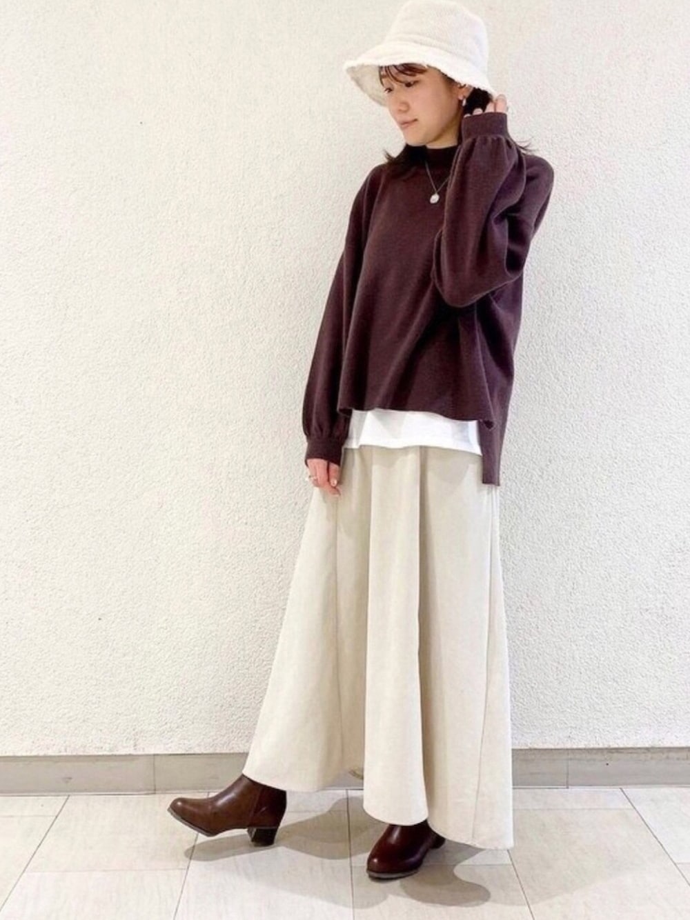 ブラウン系のブーツを着用したレディースの冬コーディネートの1枚目の写真