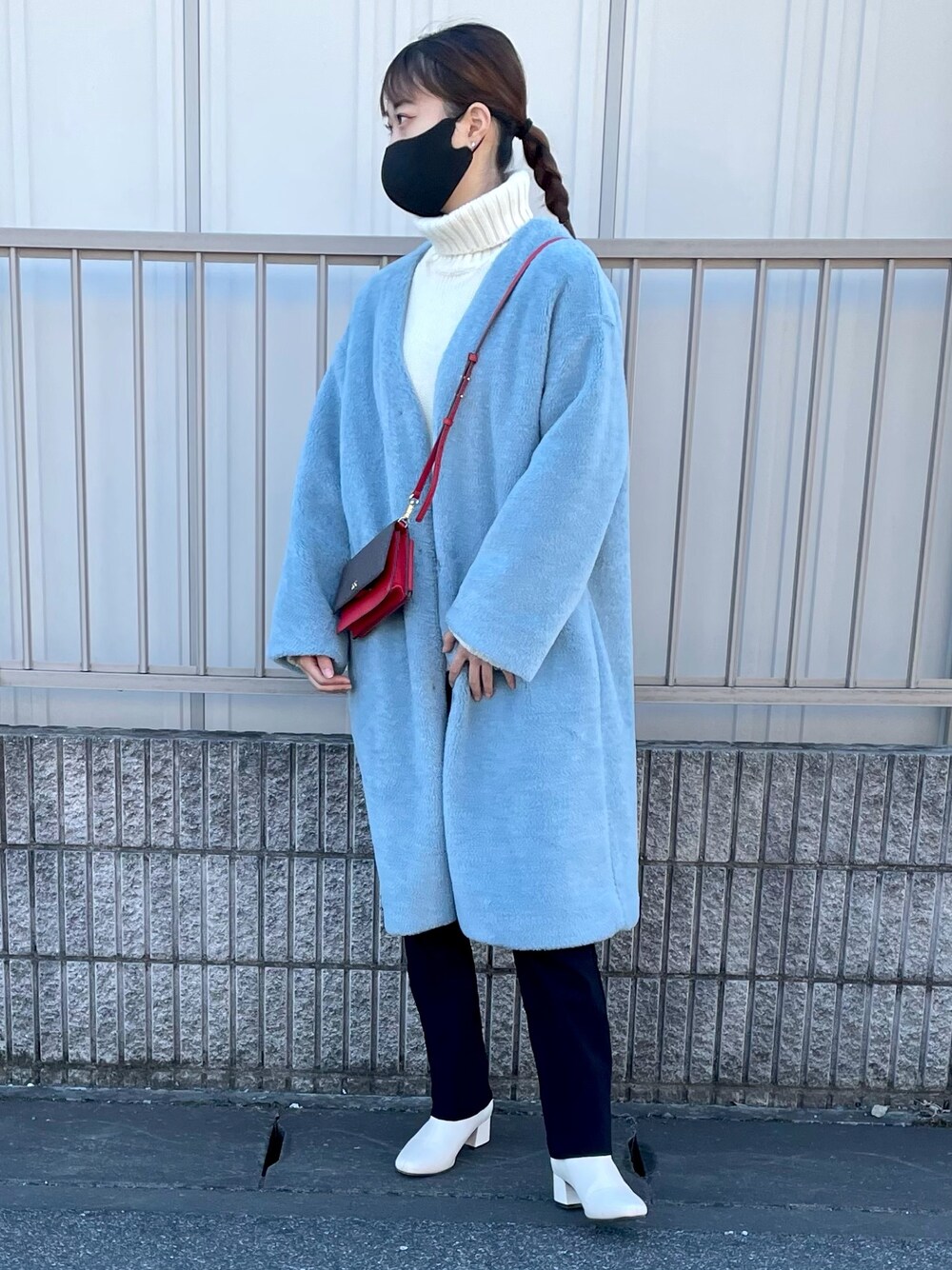 ブルー系のノーカラージャケット、レッド系のバッグを着用したレディースの冬コーディネートの1枚目の写真