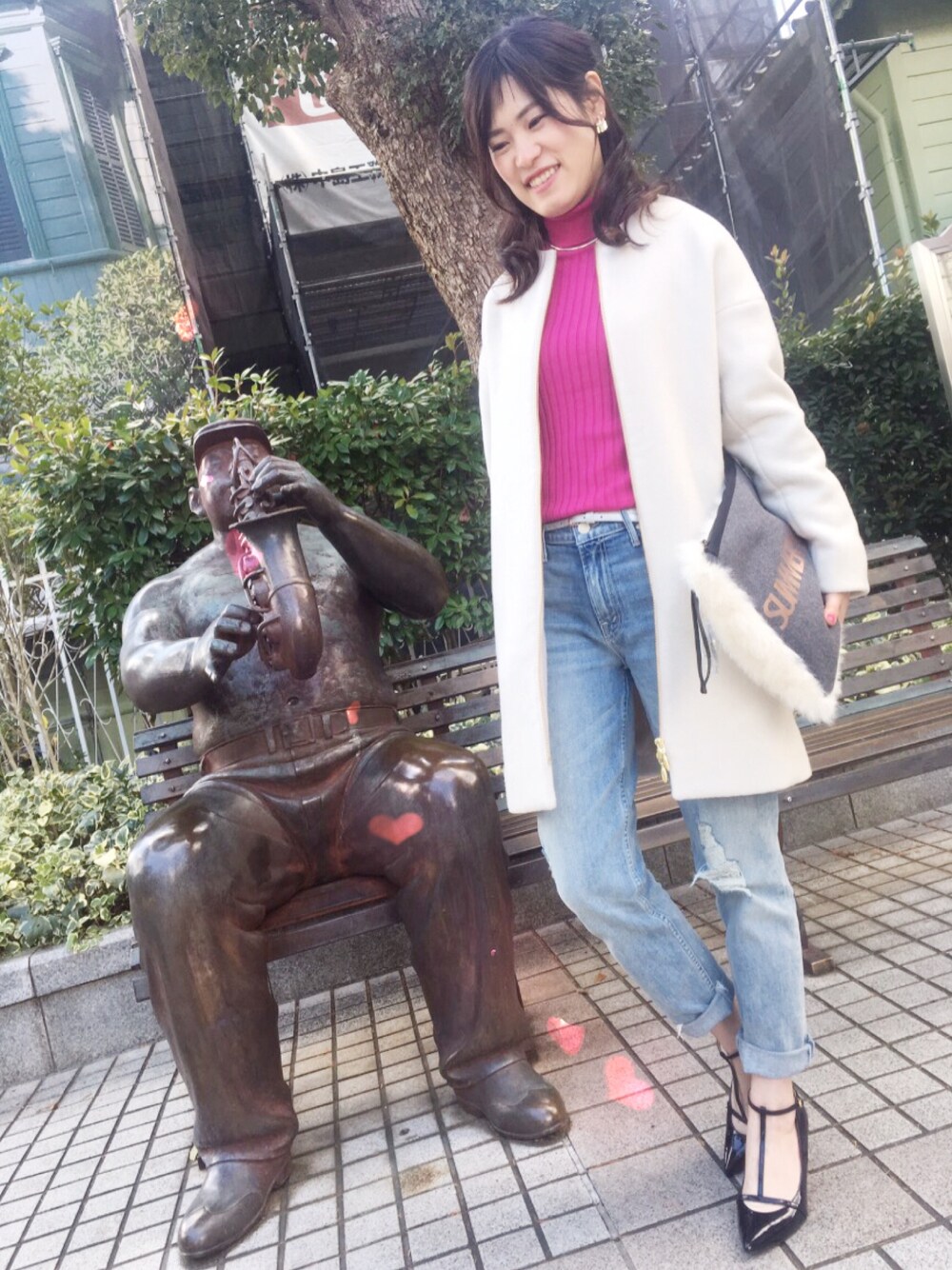 ピンク系のニット/セーター、ベージュ系のその他アウター、その他のクラッチバッグを着用したレディースの冬コーディネートの1枚目の写真