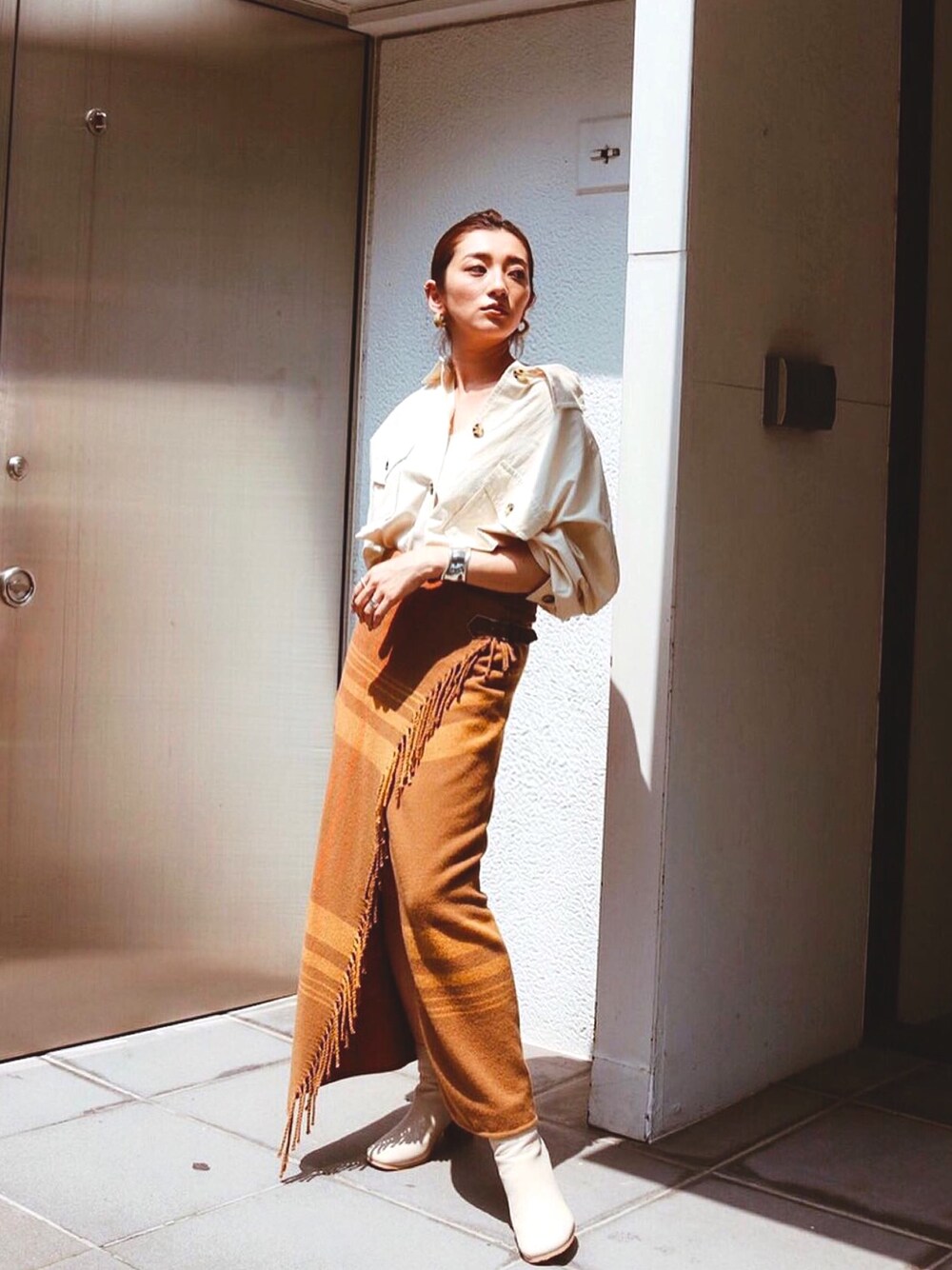 ホワイト系のシャツ/ブラウス、イエロー系のスカートを着用したレディースの秋コーディネートの1枚目の写真