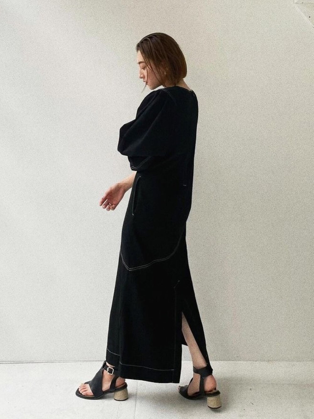 ブラック系のワンピースを着用したレディースの春コーディネートの1枚目の写真