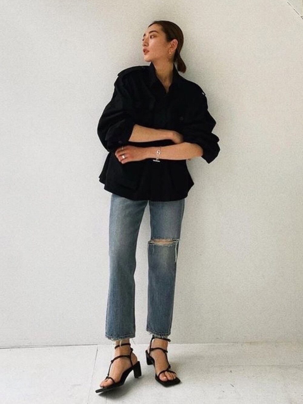 ブルー系のデニムパンツ、ブラック系のブルゾンを着用したレディースの春コーディネートの1枚目の写真