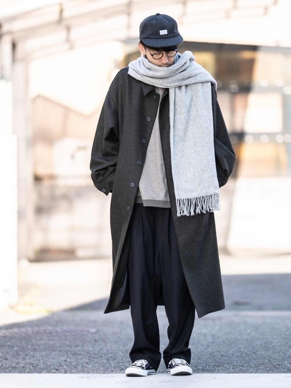 ベージュ系のTシャツ/カットソー、ブラック系のスラックス、グレー系のストール/ショールを着用したメンズの冬コーディネートの1枚目の写真