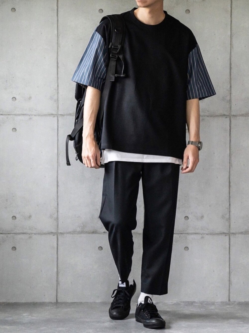 ブラック系のTシャツ/カットソー、ブラック系のスラックス、ブラック系のスニーカーを着用したメンズの春コーディネートの1枚目の写真