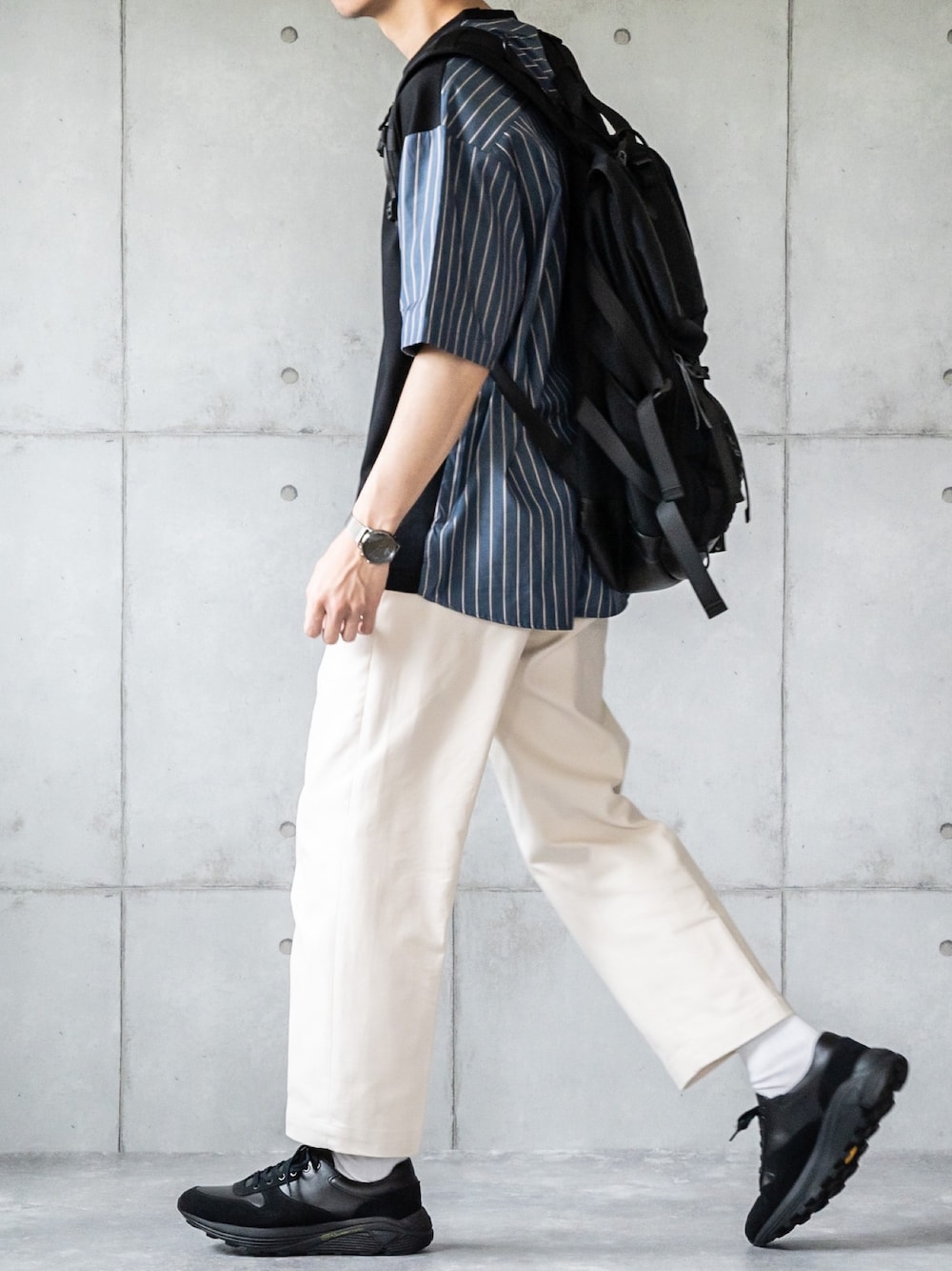 ブラック系のTシャツ/カットソー、ベージュ系のその他パンツ、ブラック系のスニーカーを着用したメンズの春コーディネートの1枚目の写真