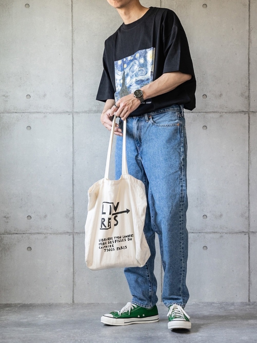 ブラック系のTシャツ/カットソー、グリーン系のスニーカー、ブルー系のデニムパンツを着用したメンズの春コーディネートの1枚目の写真