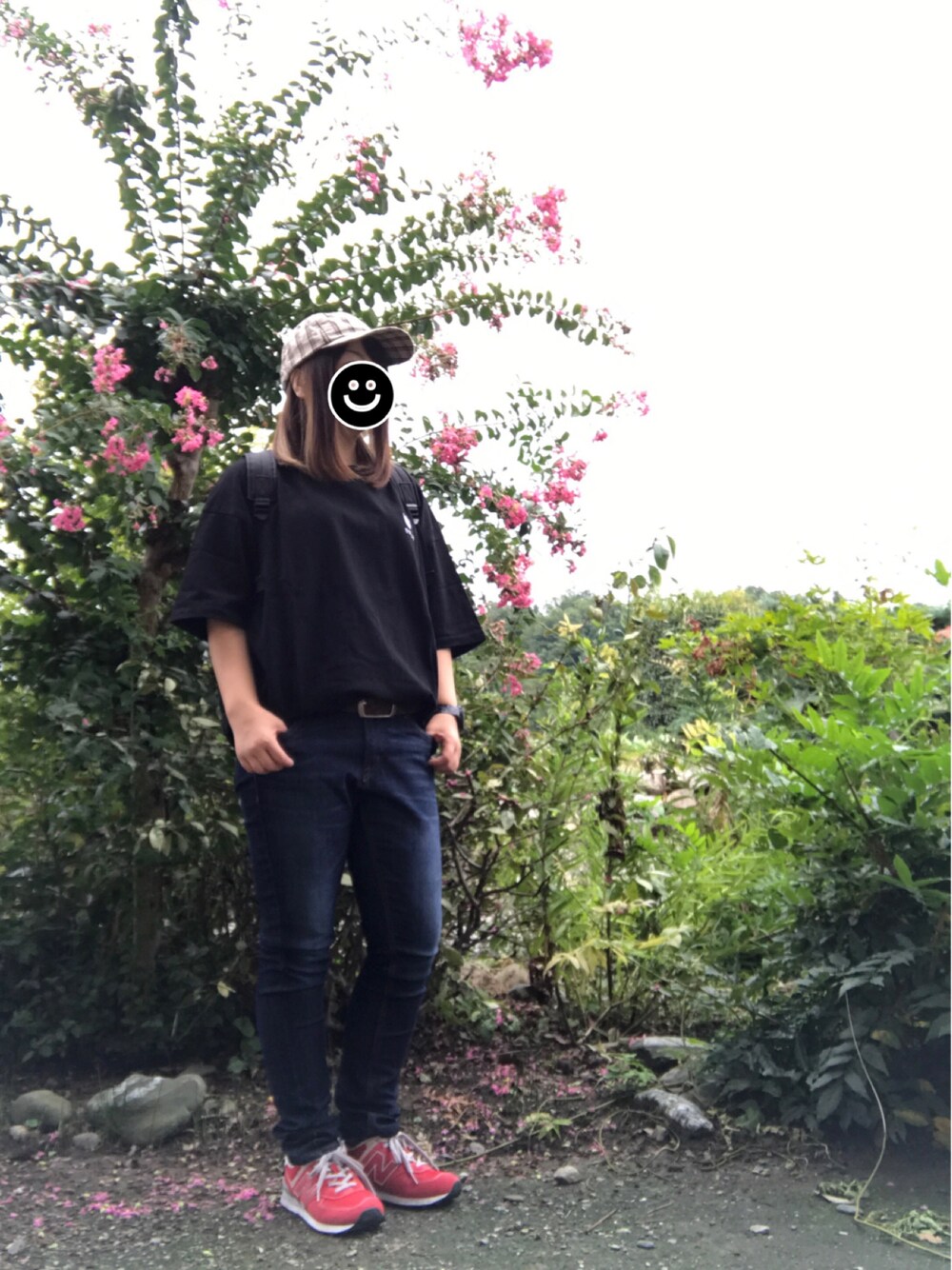 ブラック系のバックパック/リュック、ブラック系のTシャツ/カットソー、ブルー系のデニムパンツを着用したレディースの秋コーディネートの1枚目の写真