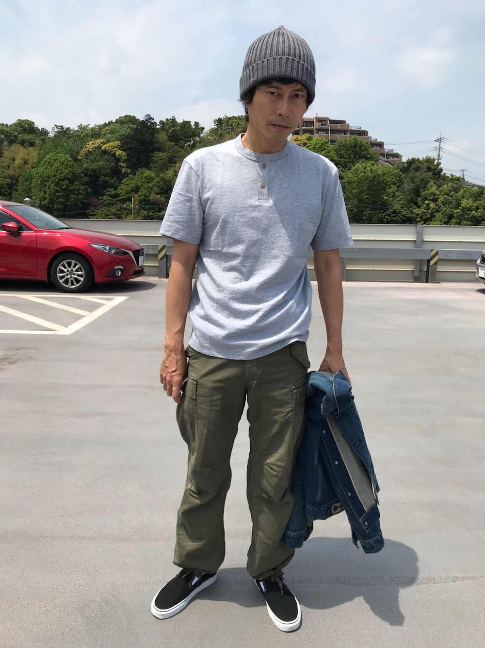 グレー系のTシャツ/カットソー、グリーン系のカーゴパンツ、ブルー系のデニムジャケットを着用したメンズの春コーディネートの1枚目の写真