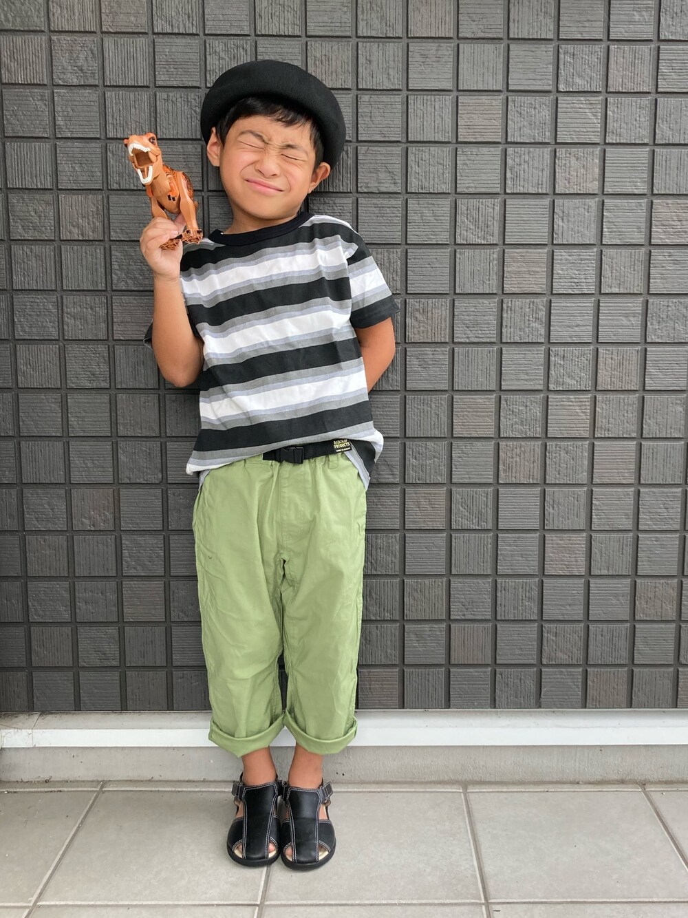 ブラック系のTシャツ/カットソー、グリーン系のその他パンツ、ブラック系のサンダルを着用したキッズの秋コーディネートの1枚目の写真