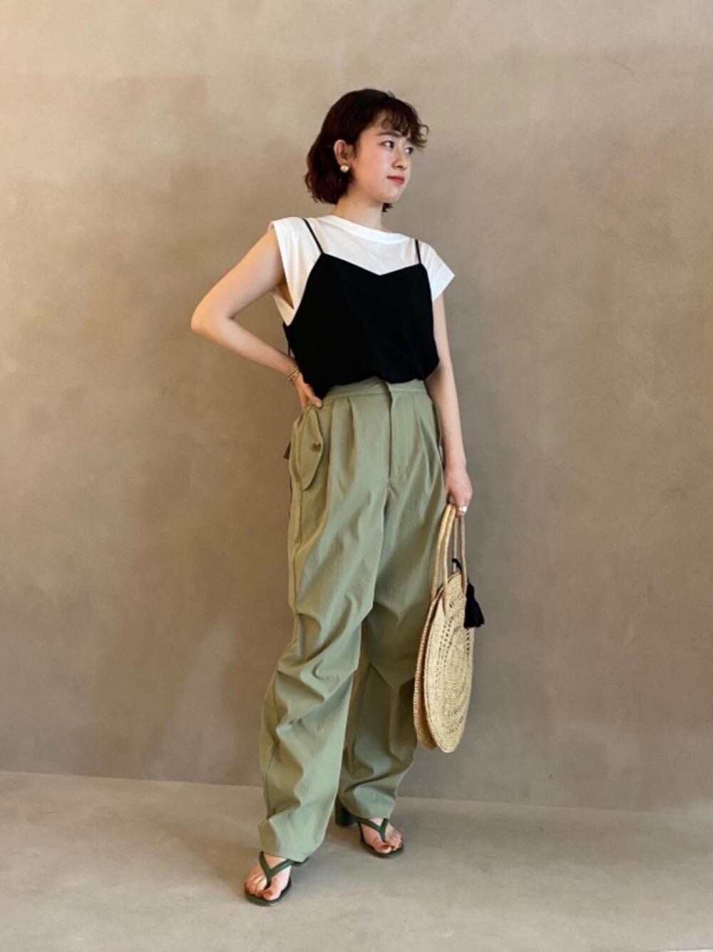 グリーン系のその他パンツ、ブラック系のキャミソール、ホワイト系のTシャツ/カットソーを着用したレディースの春コーディネートの1枚目の写真