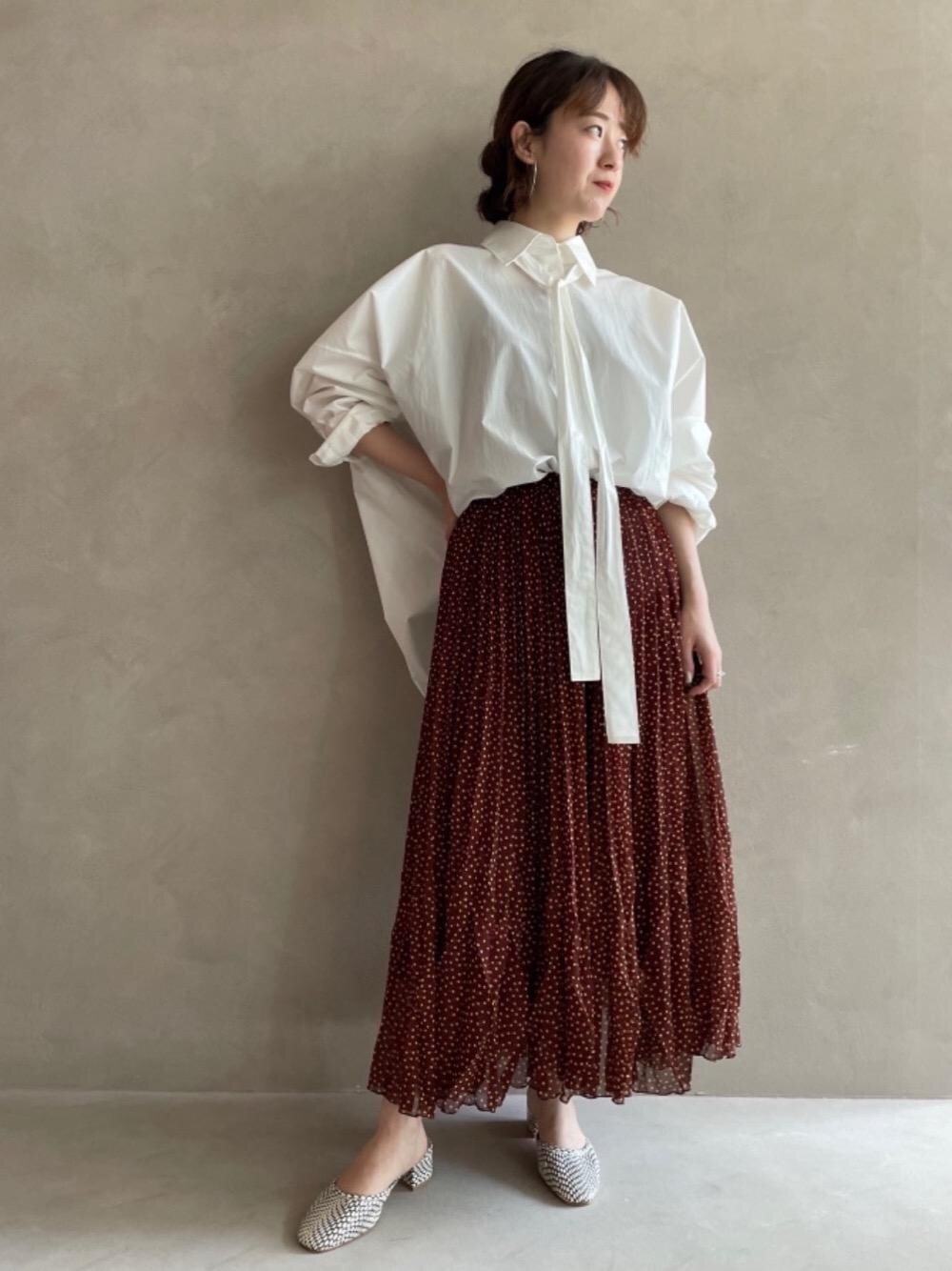 ブラウン系のスカートを着用したレディースの夏コーディネートの1枚目の写真