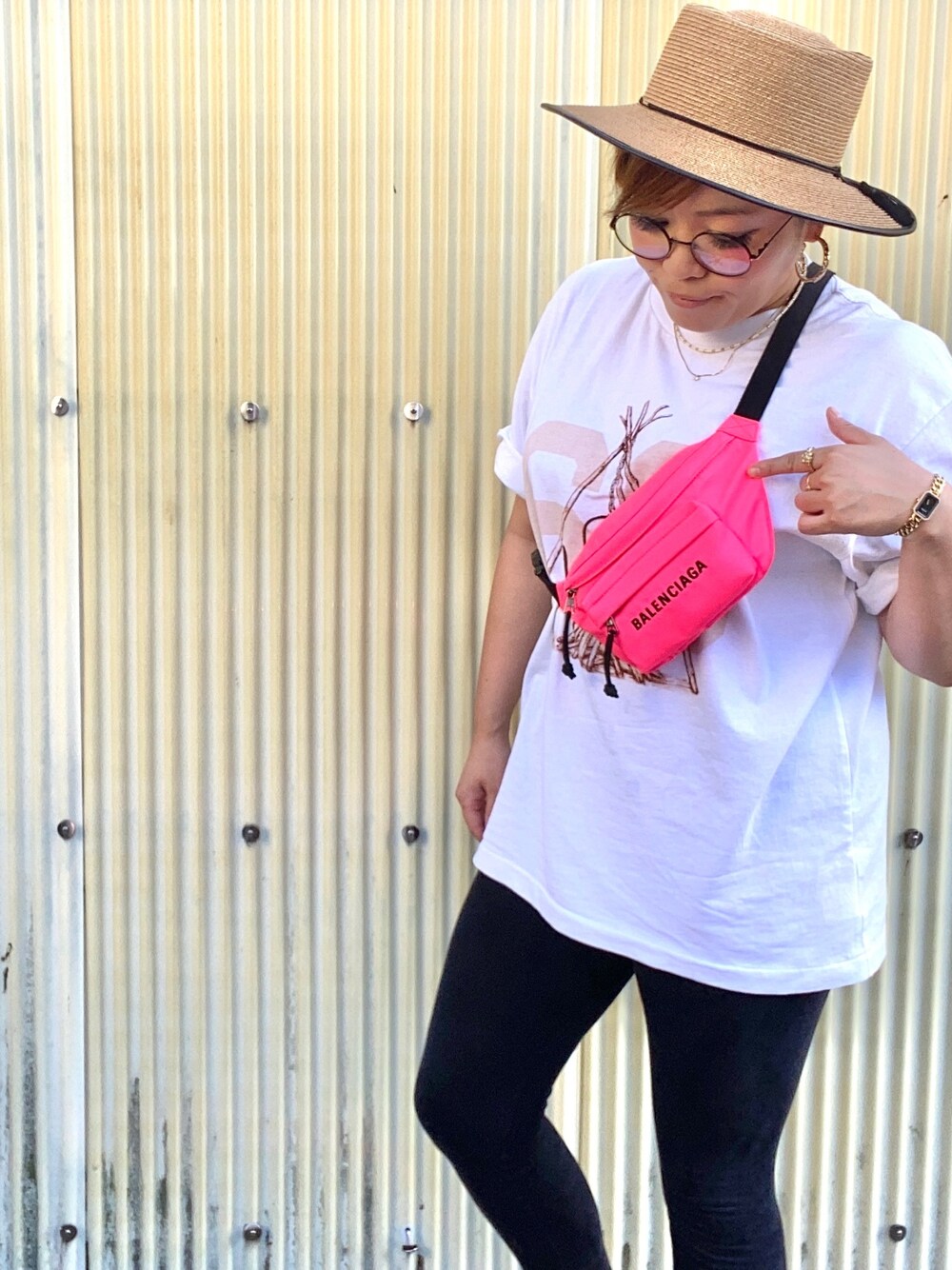 ピンク系のショルダーバッグ、ホワイト系のTシャツ/カットソー、ベージュ系のハットを着用したレディースの夏コーディネートの1枚目の写真