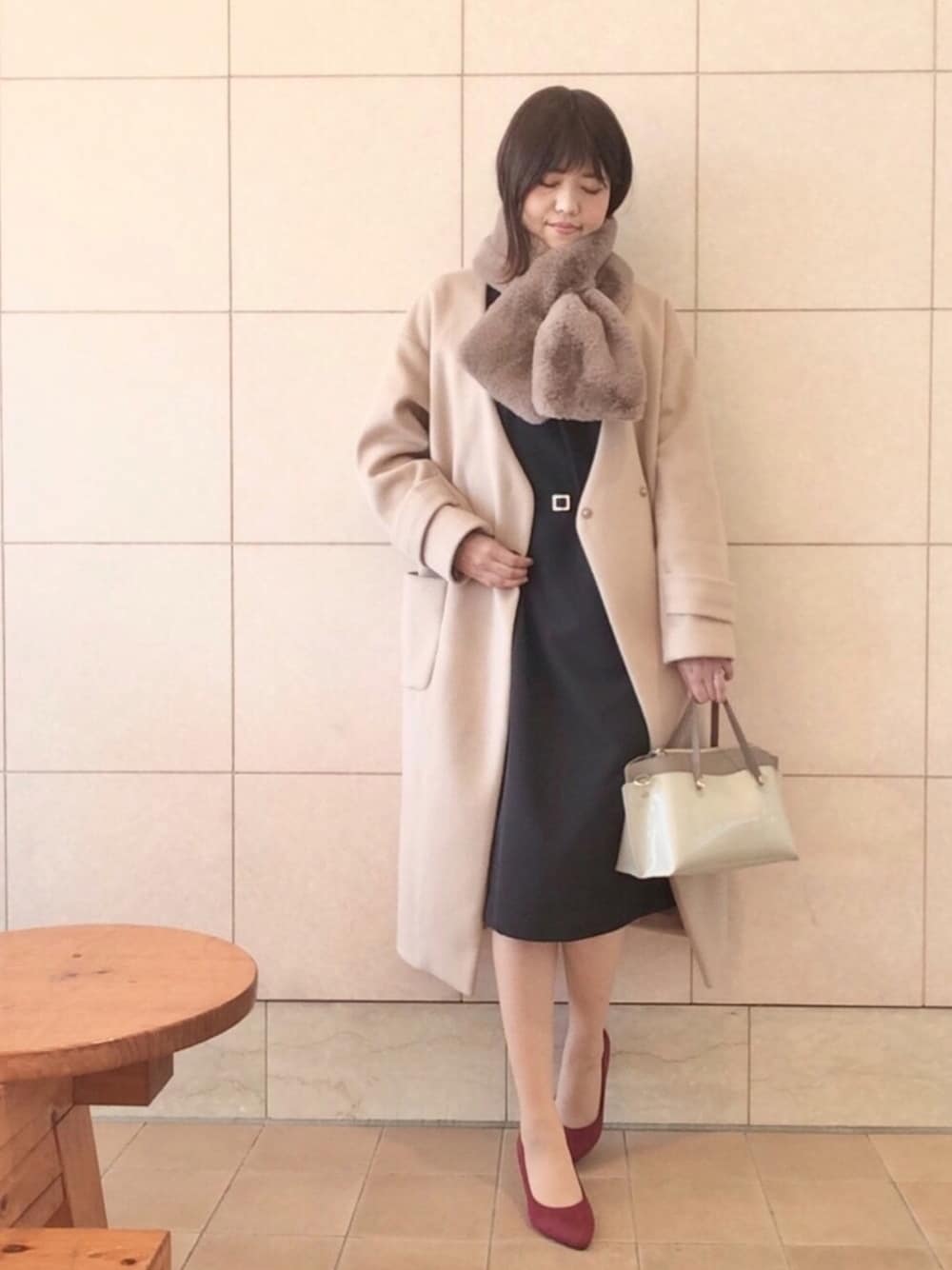 ブラック系のワンピース、ベージュ系のノーカラーコート、グレー系のショルダーバッグを着用したレディースの冬コーディネートの1枚目の写真