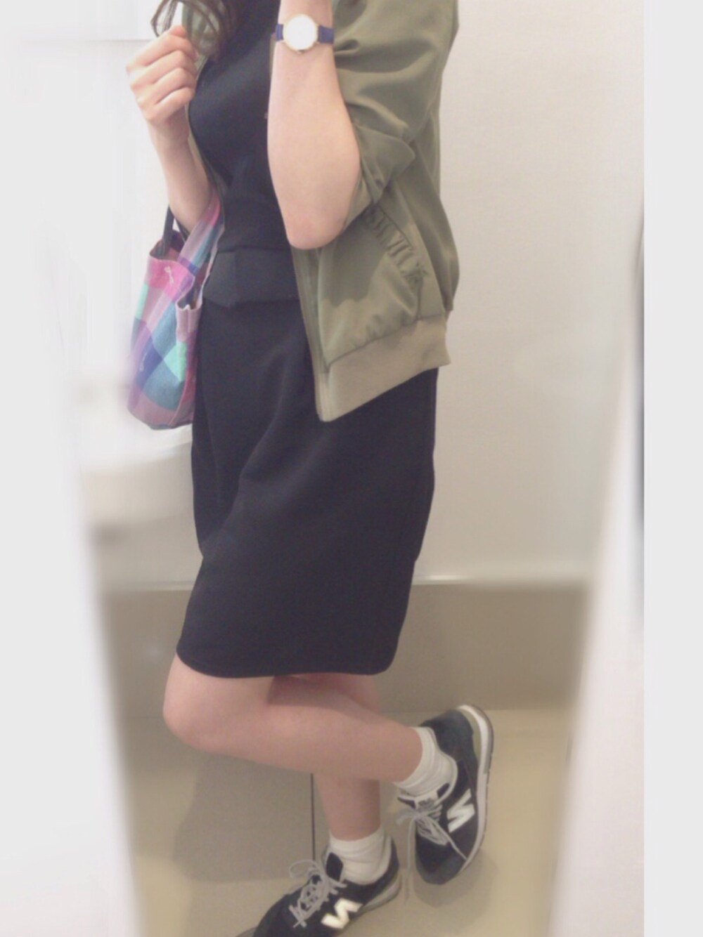 ブラック系のスカート、グリーン系のブルゾン、ブルー系のスニーカーを着用したレディースの夏コーディネートの1枚目の写真