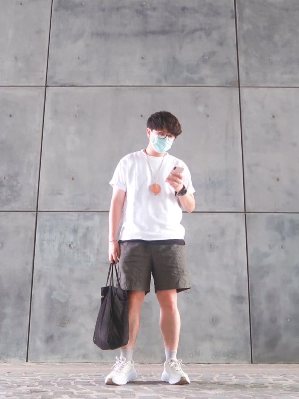 グレー系のカーゴパンツ、ベージュ系のスニーカー、ブラック系のショルダーバッグを着用したメンズの秋コーディネートの1枚目の写真