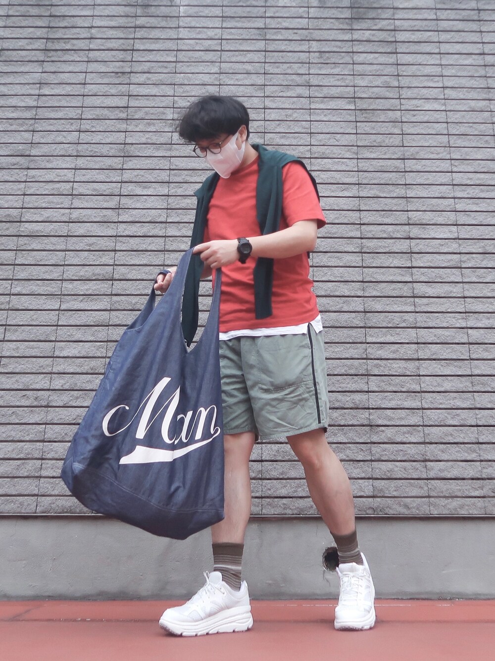 グリーン系のカーゴパンツ、レッド系のTシャツ/カットソー、ホワイト系のスニーカーを着用したメンズの春コーディネートの1枚目の写真