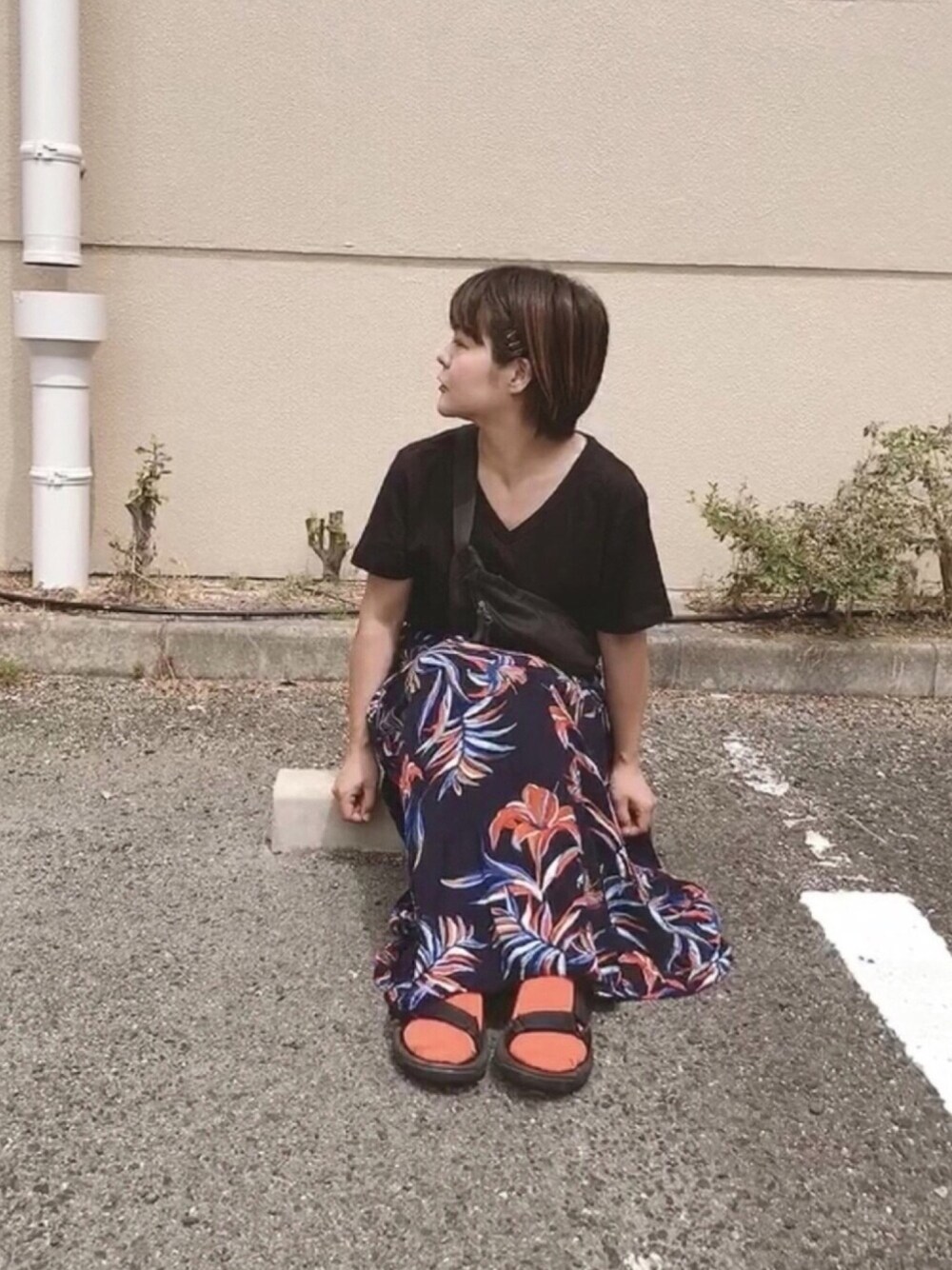 ブルー系のスカート、ブラック系のTシャツ/カットソー、ブラック系のボディバッグ/ウエストポーチを着用したレディースの夏コーディネートの1枚目の写真