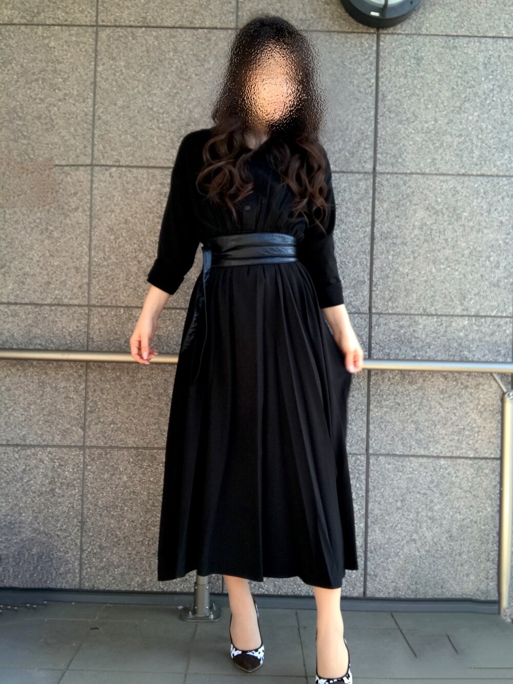 ブラック系のワンピース、ブラック系のベルトを着用したレディースの春コーディネートの1枚目の写真