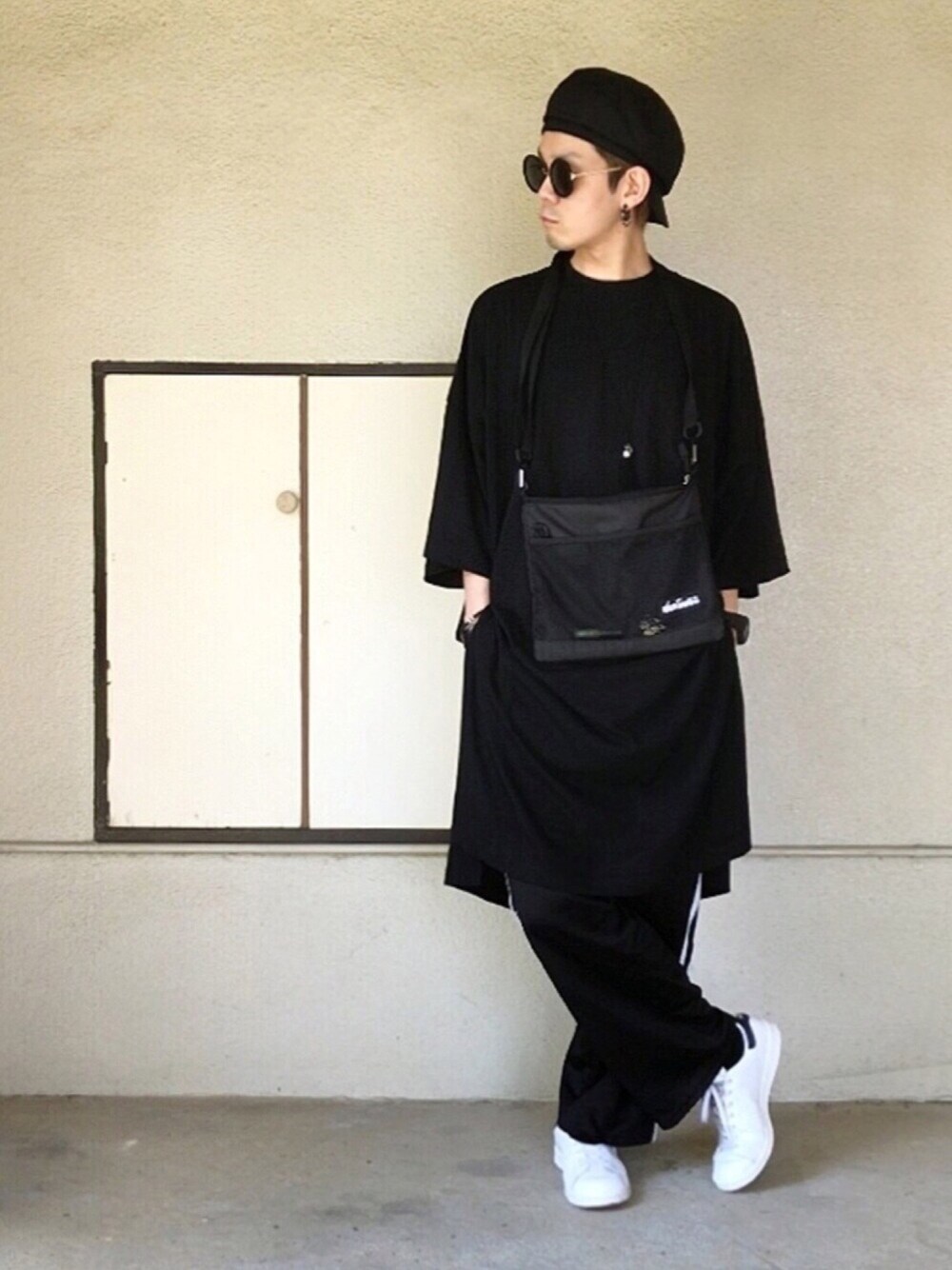 ブラック系のTシャツ/カットソー、ブラック系のパンツ、ホワイト系のスニーカーを着用したメンズの夏コーディネートの1枚目の写真