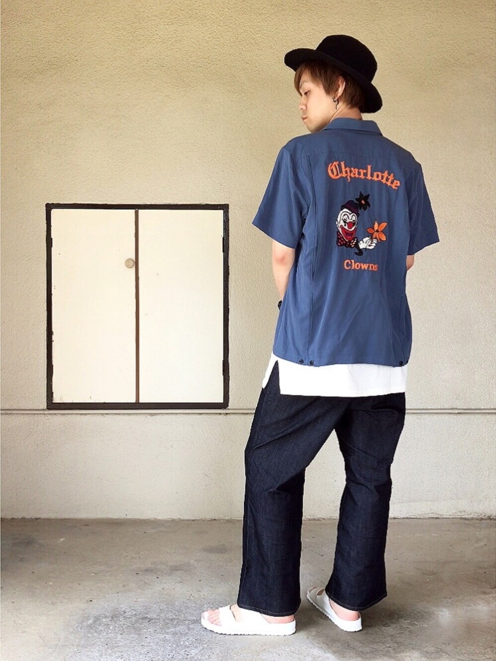 ブルー系のデニムパンツ、ホワイト系のサンダル、ホワイト系のTシャツ/カットソーを着用したメンズの夏コーディネートの1枚目の写真