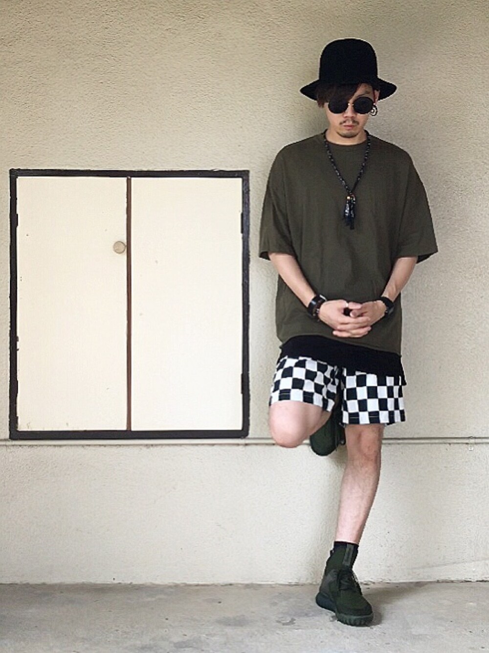 グリーン系のTシャツ/カットソー、ブラック系のタンクトップ、グリーン系のスニーカーを着用したメンズの夏コーディネートの1枚目の写真