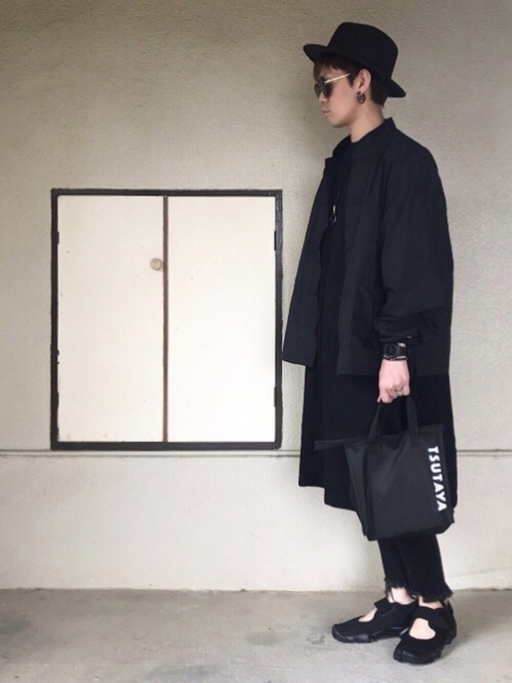 ブラック系のナイロンジャケット、ブラック系のTシャツ/カットソー、ブラック系のデニムパンツを着用したメンズの春コーディネートの1枚目の写真