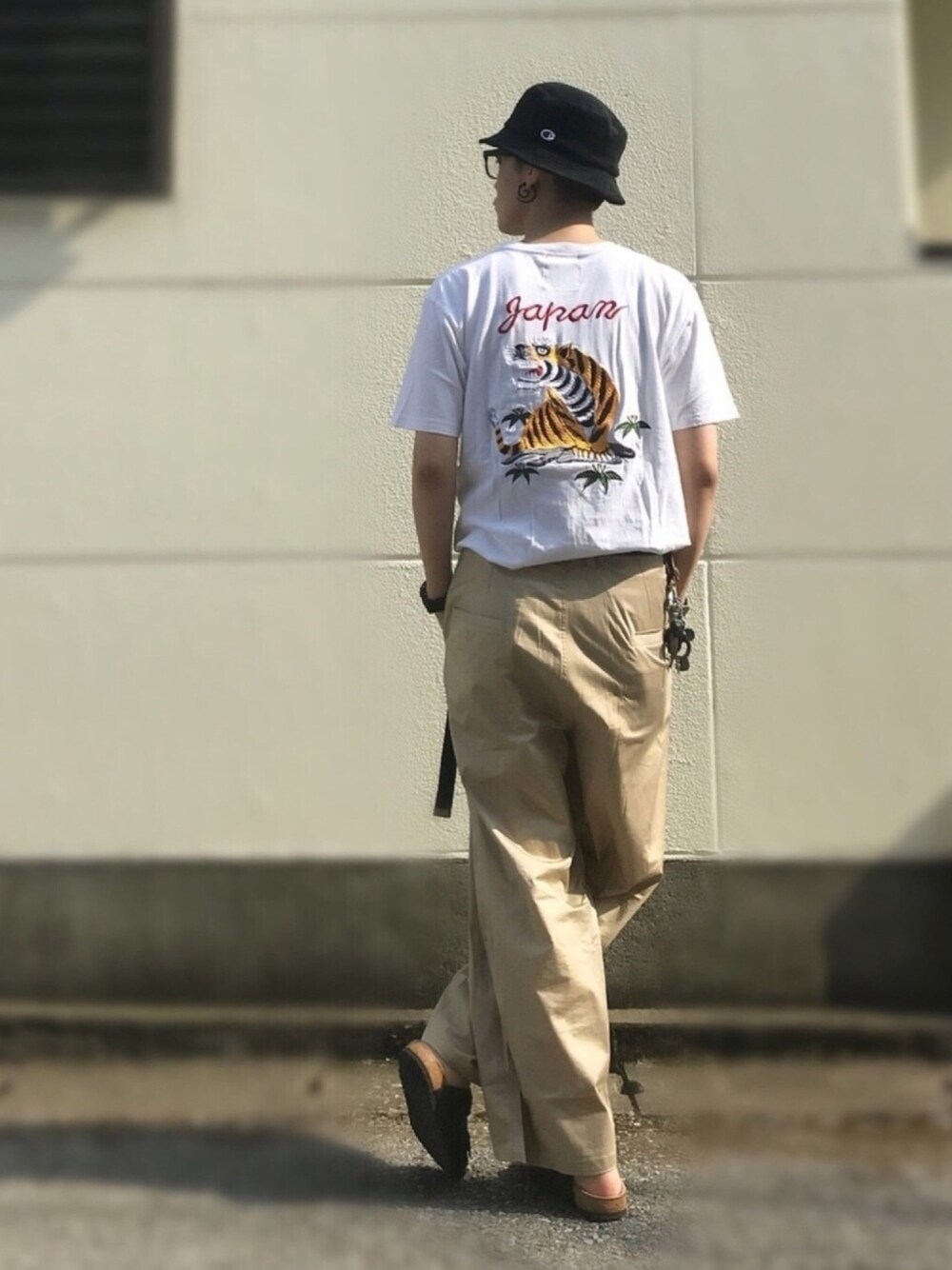 ホワイト系のTシャツ/カットソー、ベージュ系のチノパンツ、ブラック系のサンダルを着用したメンズの夏コーディネートの1枚目の写真