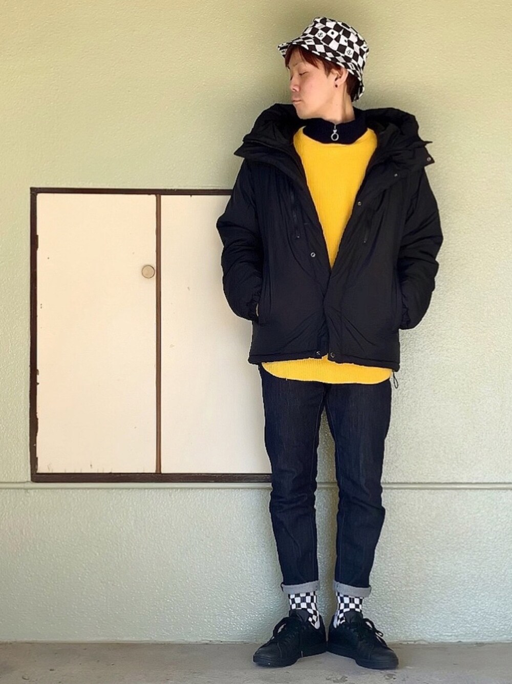 ブラック系のスニーカー、ブルー系のデニムパンツ、ブルー系のニット/セーターを着用したメンズの冬コーディネートの1枚目の写真