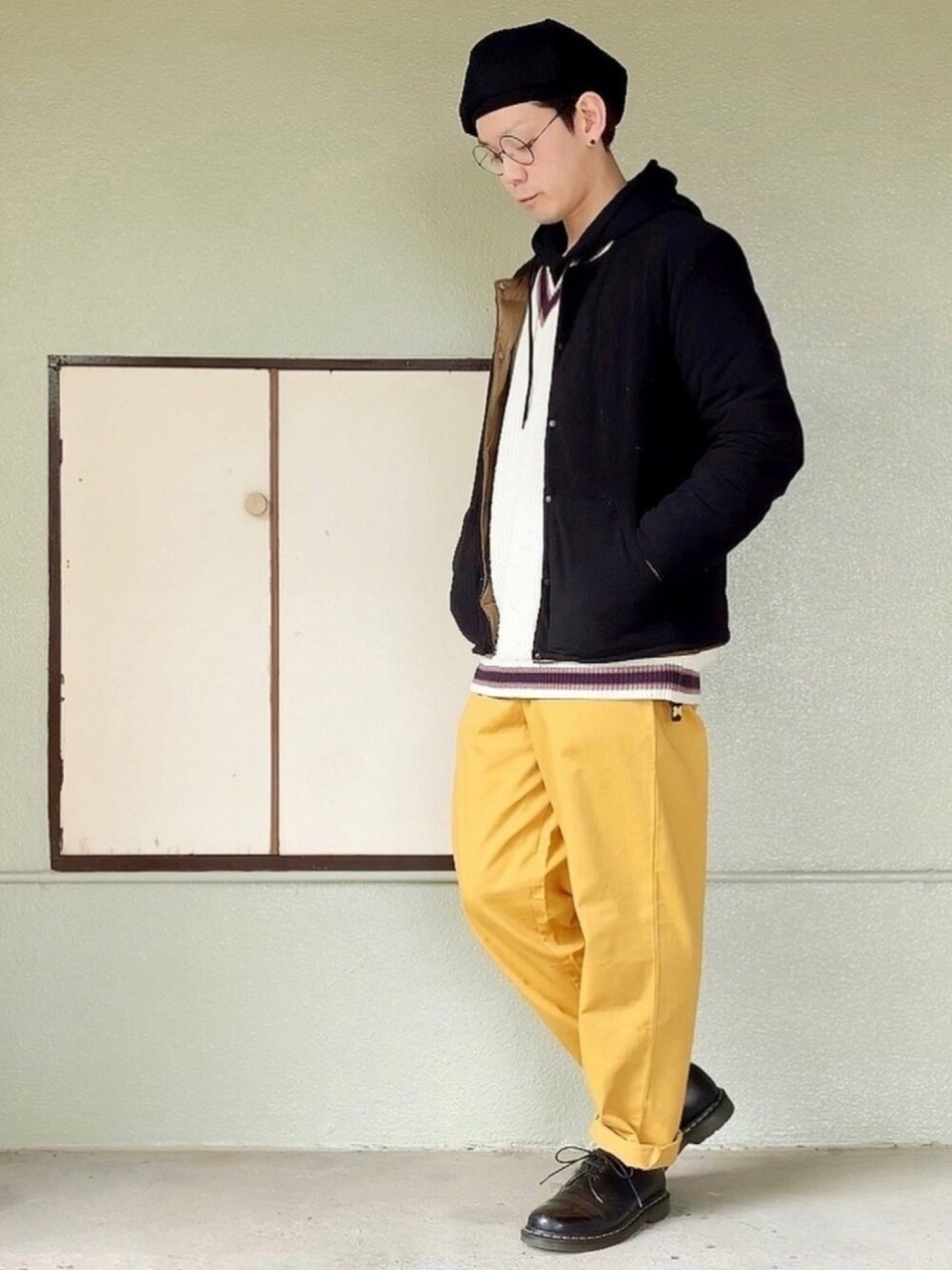 ブラック系のブーツ、イエロー系のその他パンツ、ブラック系のパーカーを着用したメンズの冬コーディネートの1枚目の写真