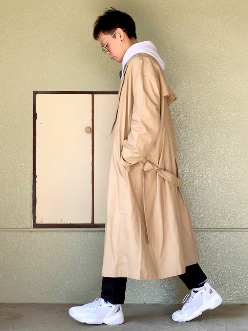 ホワイト系のスニーカー、ブラック系のチノパンツ、ホワイト系のパーカーを着用したメンズの春コーディネートの1枚目の写真