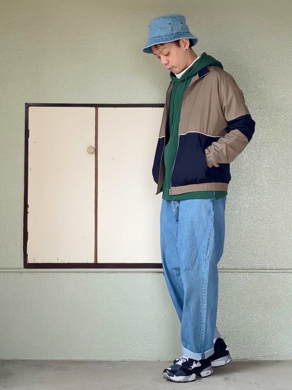 ベージュ系のナイロンジャケット、グリーン系のパーカー、ホワイト系のTシャツ/カットソーを着用したメンズの春コーディネートの1枚目の写真
