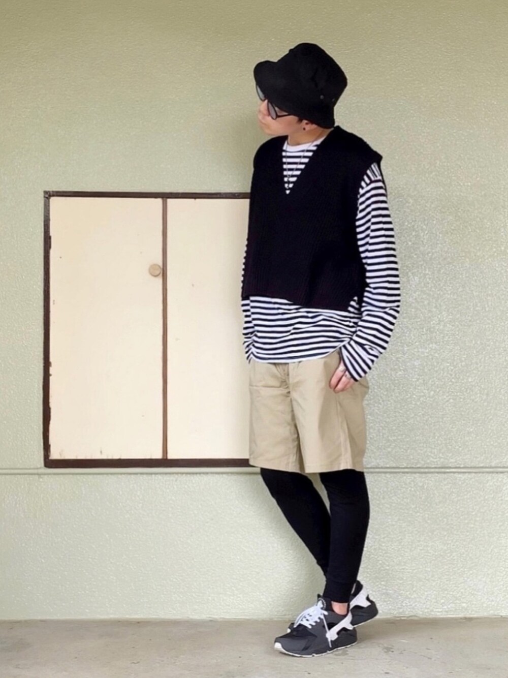 ブラック系のスニーカー、ベージュ系のパンツ、その他のTシャツ/カットソーを着用したメンズの春コーディネートの1枚目の写真
