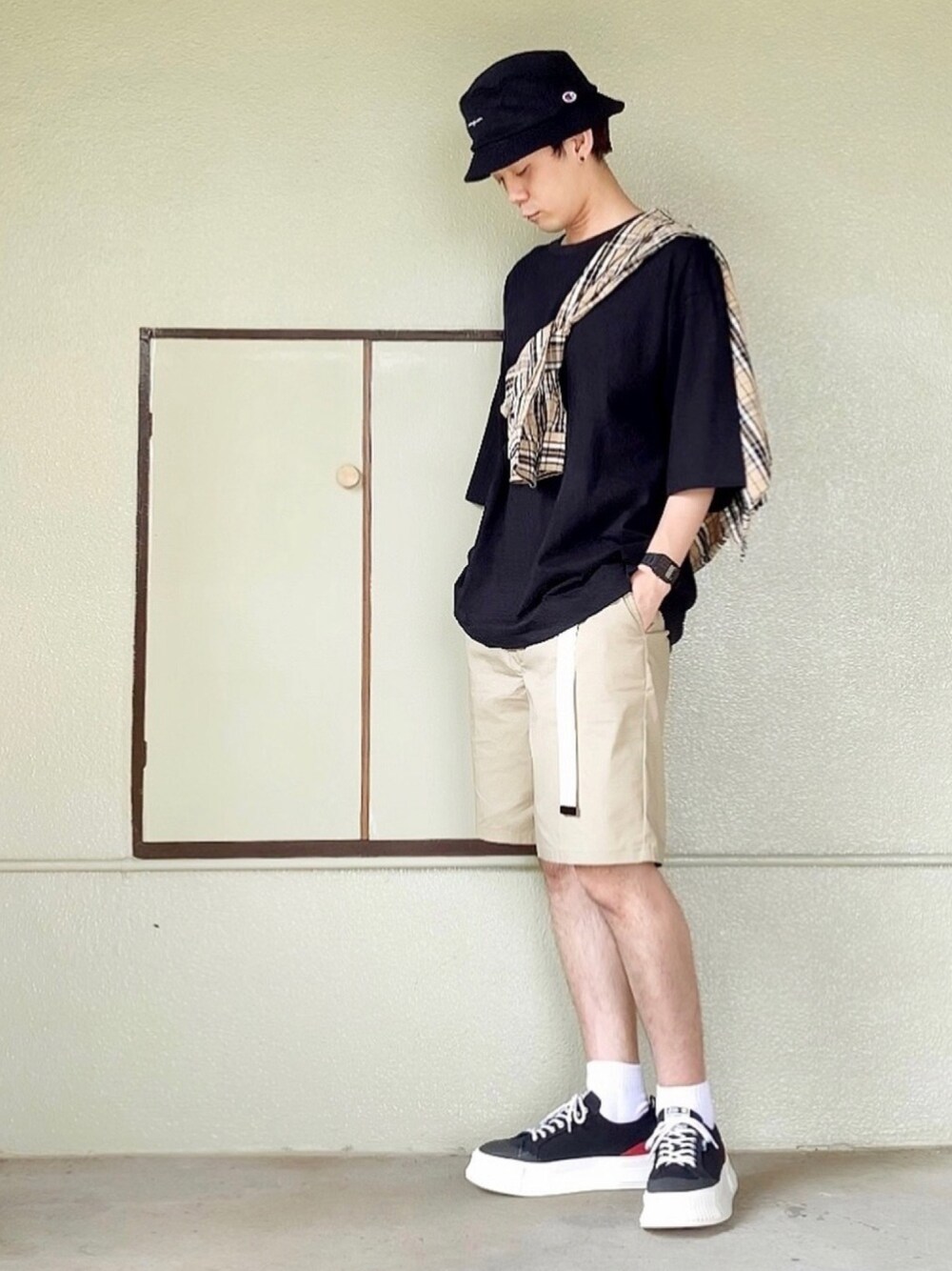 ブラック系のスニーカー、ベージュ系のパンツ、ブラック系のTシャツ/カットソーを着用したメンズの秋コーディネートの1枚目の写真