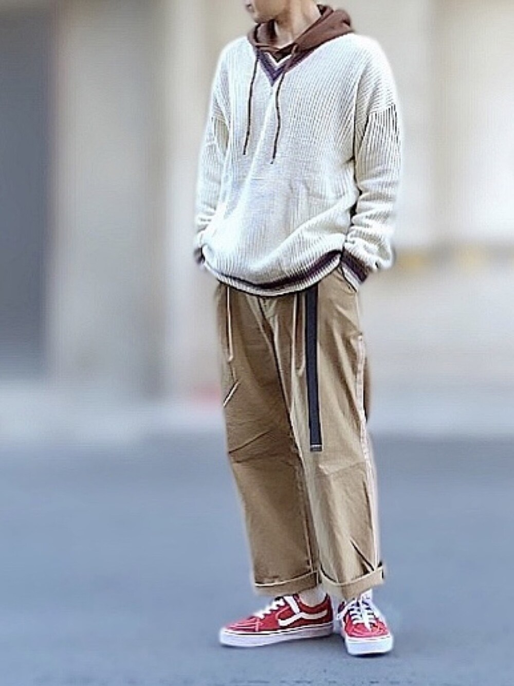 レッド系のスニーカー、ベージュ系のチノパンツ、ブラウン系のパーカーを着用したメンズの冬コーディネートの1枚目の写真
