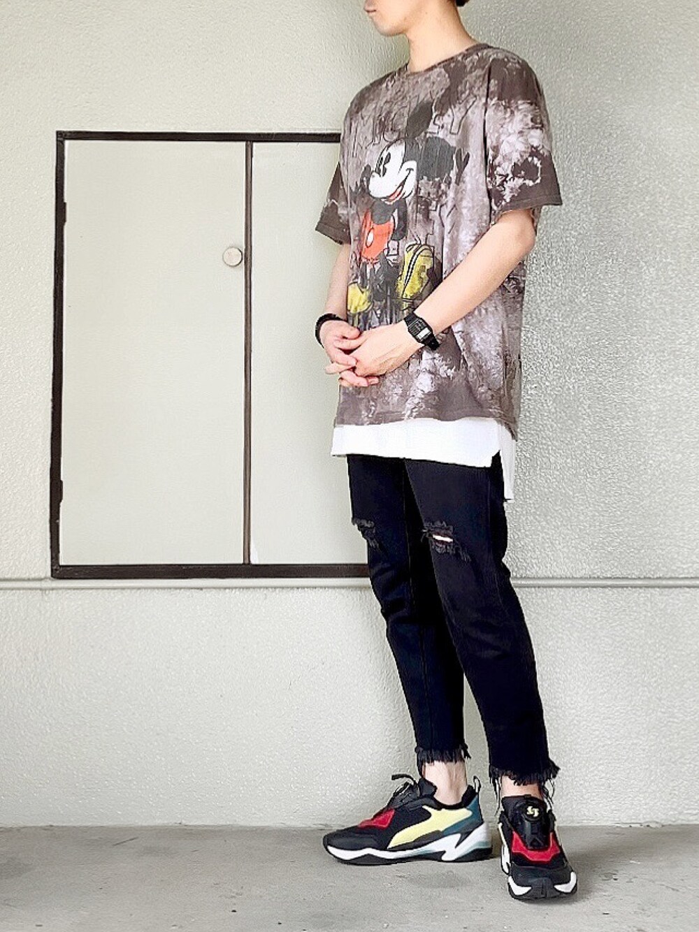 ブラック系のスニーカー、ブラック系のデニムパンツ、ホワイト系のタンクトップを着用したメンズの春コーディネートの1枚目の写真