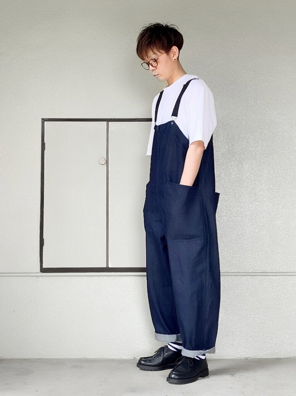ブルー系のサロペット/オーバーオール、ホワイト系のTシャツ/カットソー、ブラック系のドレスシューズを着用したメンズの夏コーディネートの1枚目の写真