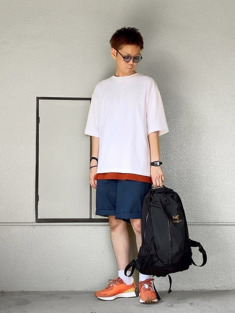 ホワイト系のTシャツ/カットソー、オレンジ系のTシャツ/カットソー、ブルー系のパンツを着用したメンズの夏コーディネートの1枚目の写真