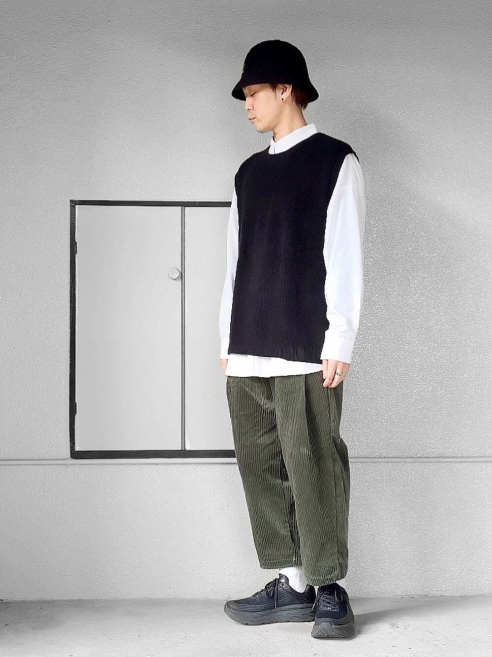 ブラック系のニット/セーター、ホワイト系のシャツ/ブラウス、グリーン系のセットアップを着用したメンズの秋コーディネートの1枚目の写真