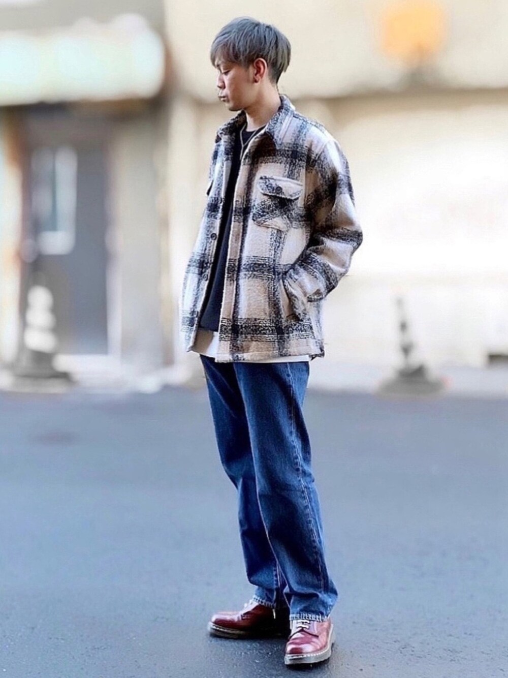 ブルー系のデニムパンツ、ホワイト系のジャケット/アウター、ブラック系のニット/セーターを着用したメンズの冬コーディネートの1枚目の写真