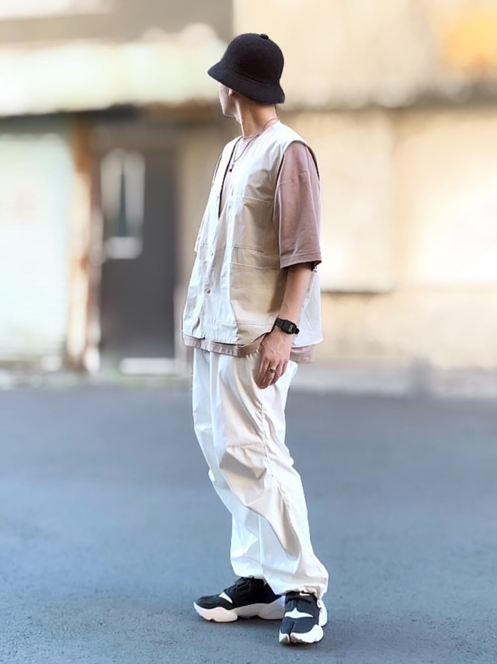 ブラウン系のTシャツ/カットソー、ベージュ系のベスト、ホワイト系のその他パンツを着用したメンズの春コーディネートの1枚目の写真