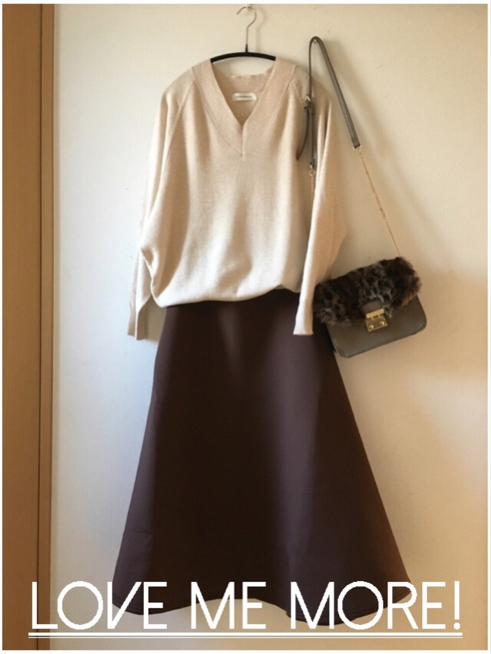 ベージュ系のニット/セーター、ブラウン系のスカート、その他のショルダーバッグを着用したレディースの冬コーディネートの1枚目の写真