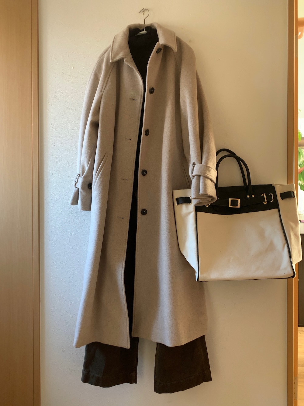 ブラック系のトートバッグ、グリーン系のその他パンツ、ホワイト系のジャケット/アウターを着用したレディースの冬コーディネートの1枚目の写真