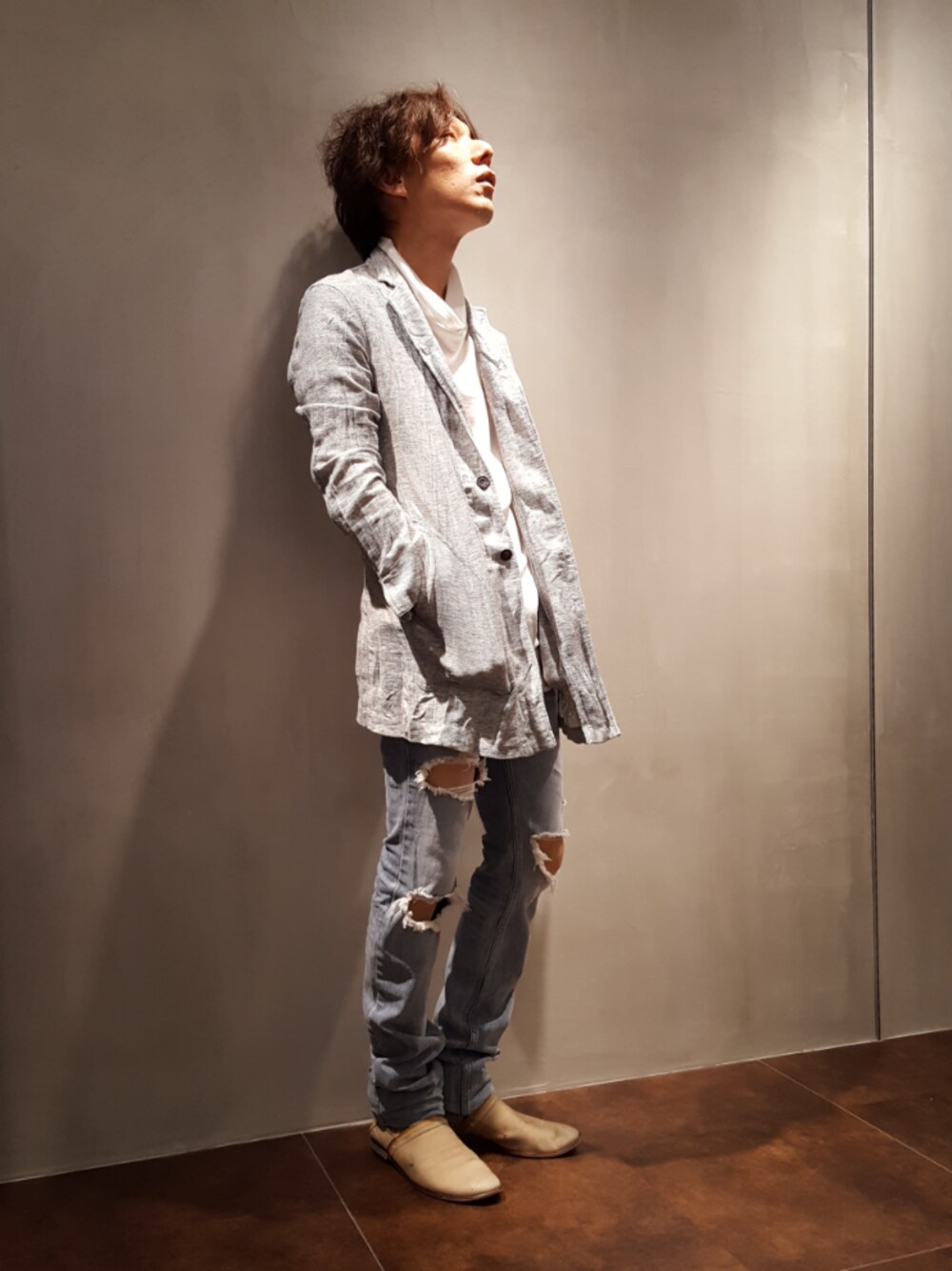 グレー系のブルゾン、ブルー系のデニムパンツ、ベージュ系のスリッポンを着用したメンズの春コーディネートの1枚目の写真