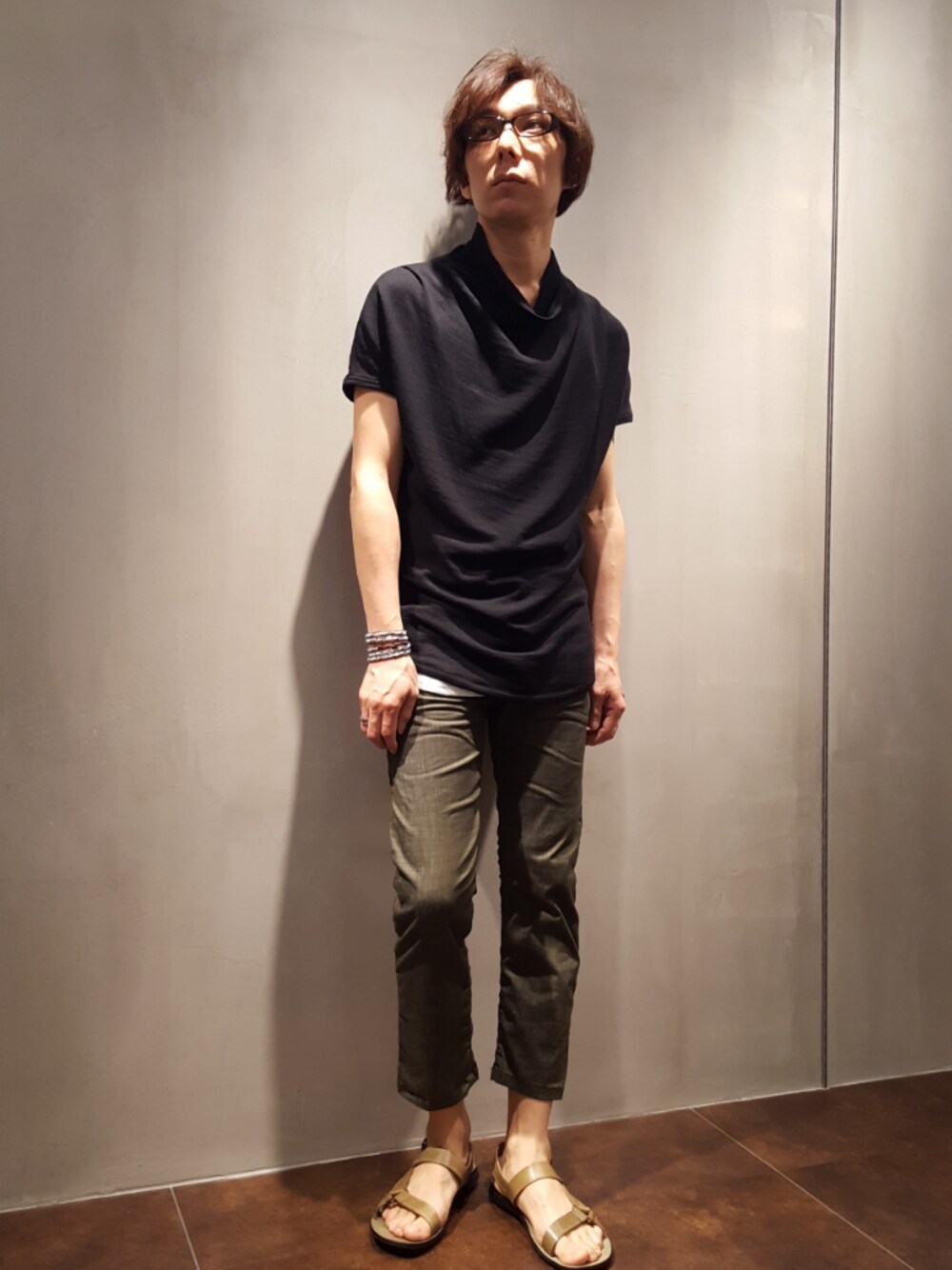 ブラック系のTシャツ/カットソー、グリーン系のデニムパンツ、グリーン系のサンダルを着用したメンズの夏コーディネートの1枚目の写真