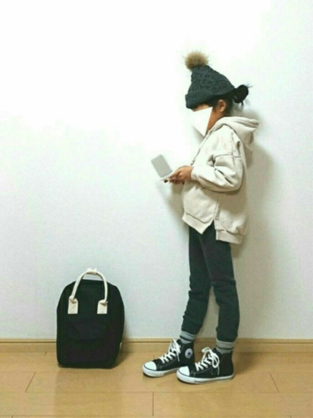 ホワイト系のスウェット、ブラック系のバックパック/リュック、グレー系のパンツを着用したキッズの冬コーディネートの1枚目の写真